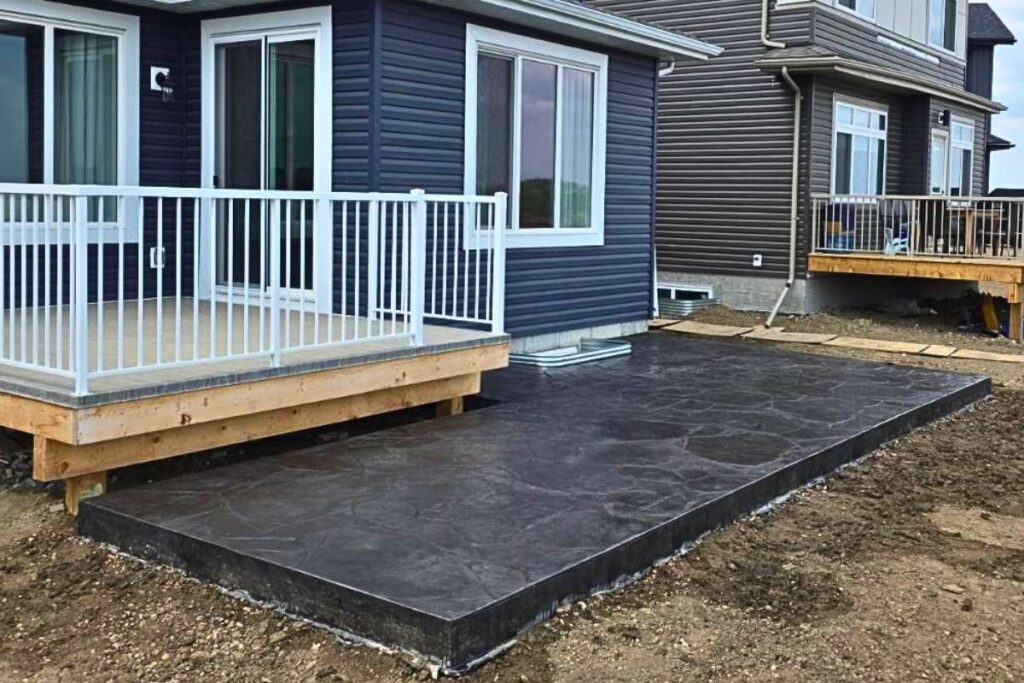 Large stamped and coloured decorative concrete patio in Edmonton for a backyard living space.