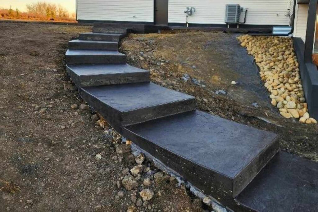 Custom coloured winding decorative concrete stairs in Edmonton area, built into a landscaped hill on an Edmonton acreage.
