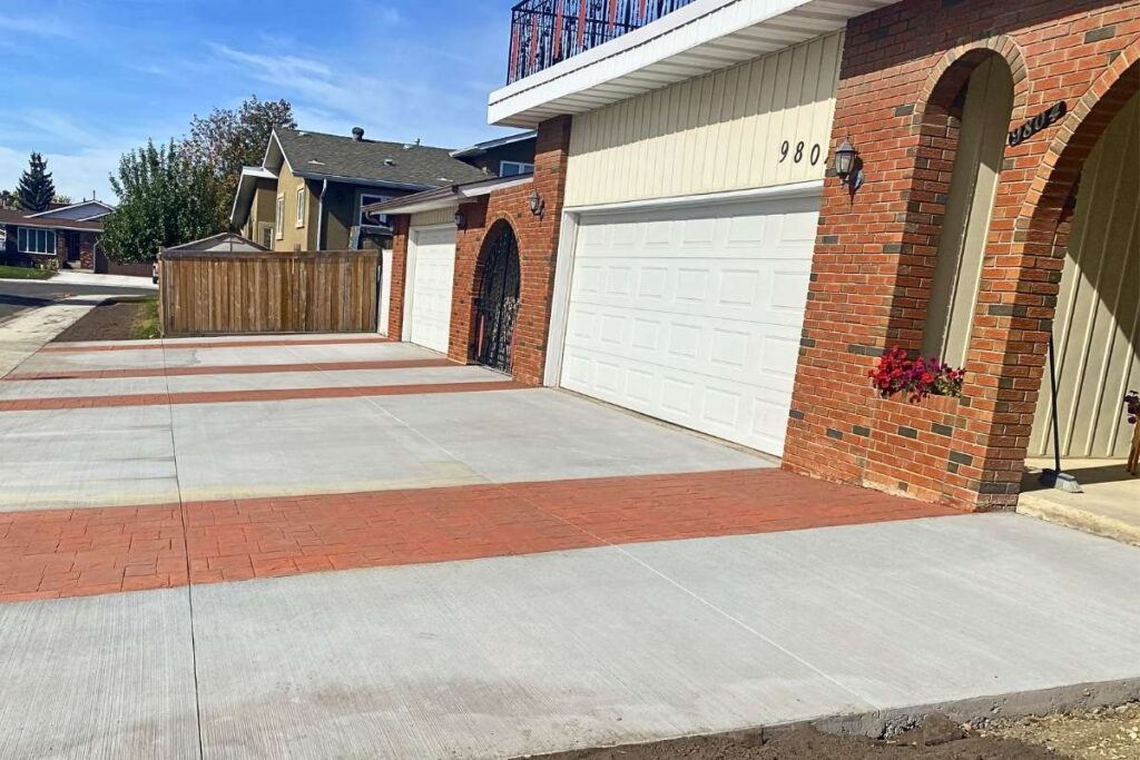 A custom residential decorative concrete driveway in Edmonton featuring decorative terra cotta stamped borders.