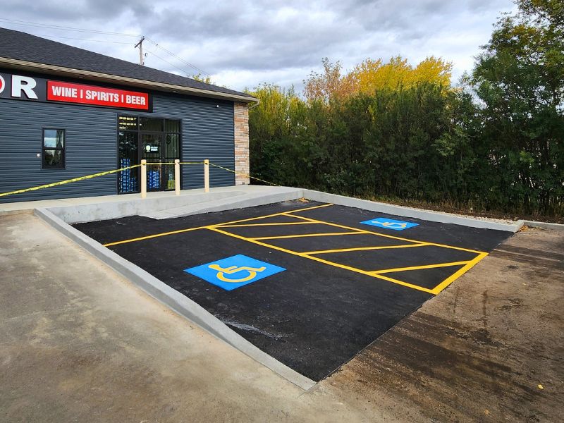 Asphalt parking lot pothole repair and patching completed outside an active commercial business in Edmonton