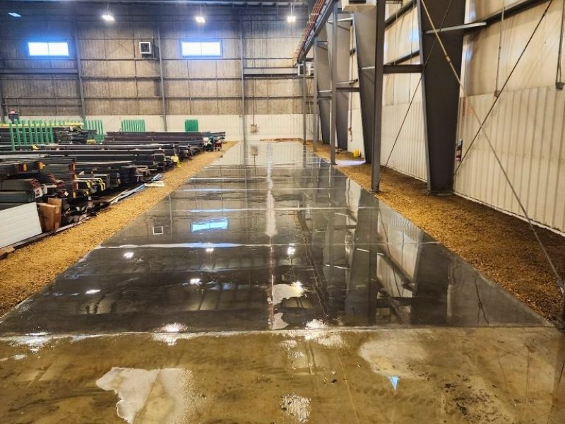 100-foot precision industrial concrete equipment pad poured for a plasma cutting table at Varsteel in Edmonton.